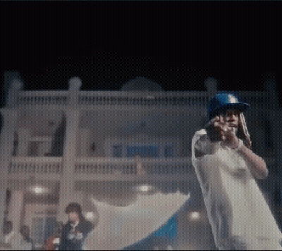 A Man Wearing A Dodgers Hat Is Standing In Front Of A House . GIF