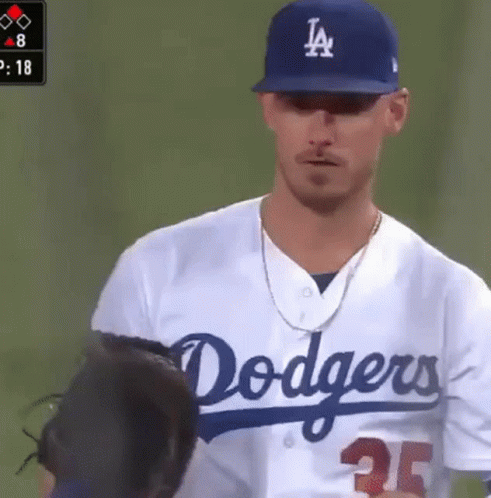 A Man Wearing A Dodgers Jersey Is Standing On A Baseball Field GIF