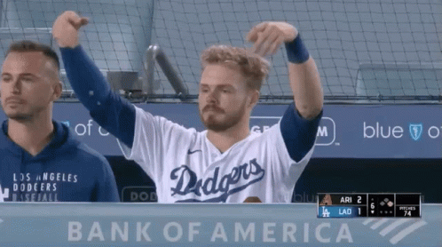 A Man Wearing A Dodgers Jersey Stands In Front Of A Bank Of America Sign GIF