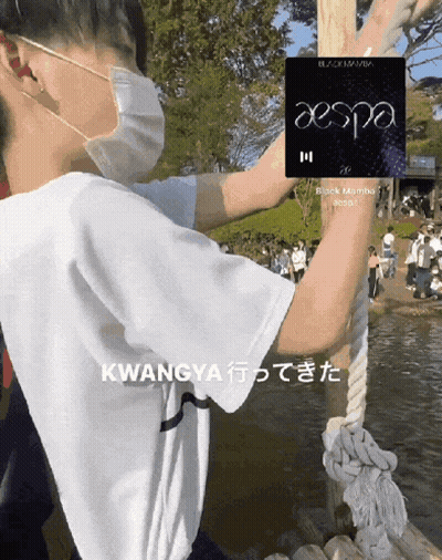 A Man Wearing A Face Mask Holds Onto A Rope With A Aespa Logo On It GIF