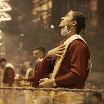 A Man Wearing A Face Mask Stands With His Eyes Closed And His Hands On His Chest GIF