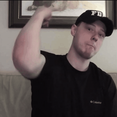 A Man Wearing A Fd Hat And A Columbia Shirt Flexes His Arm GIF