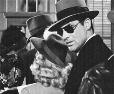 A Man Wearing A Fedora And Sunglasses Is Standing Next To A Woman GIF