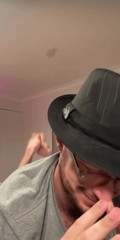 A Man Wearing A Fedora Hat With A Skull On It GIF