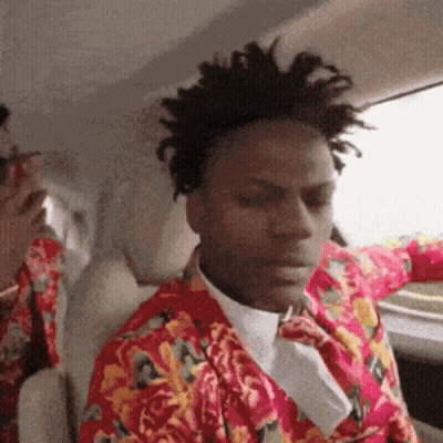 A Man Wearing A Floral Shirt And Tie Is Sitting In A Car GIF