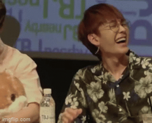 A Man Wearing A Floral Shirt Is Laughing While Holding A Stuffed Animal GIF