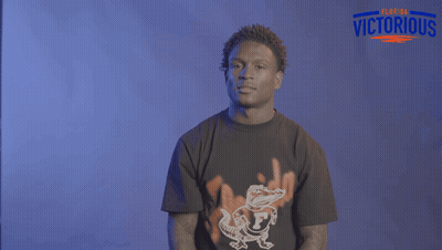 A Man Wearing A Florida Victorious Shirt Holds His Hands Up GIF