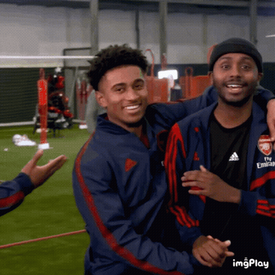 A Man Wearing A Fly Emirates Jacket Hugs Another Man On A Field GIF