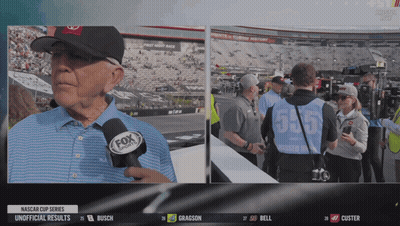 A Man Wearing A Fox Sports Microphone Talks To A Group Of People GIF