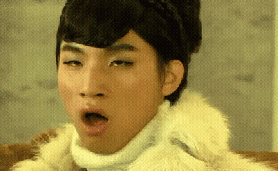 A Man Wearing A Fur Coat And A White Turtleneck Is Making A Funny Face GIF