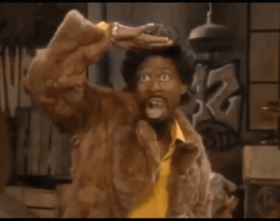 A Man Wearing A Fur Coat And A Yellow Shirt Is Making A Funny Face GIF