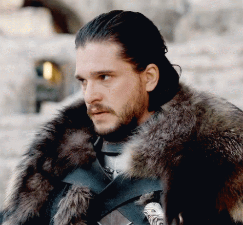 A Man Wearing A Fur Coat Looks To The Side GIF