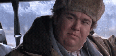 A Man Wearing A Fur Hat And A Jacket Is Sitting In A Car . GIF