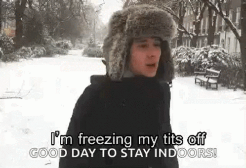 A Man Wearing A Fur Hat Is Standing In The Snow And Saying `` I 'M Freezing My Tits Off . GIF