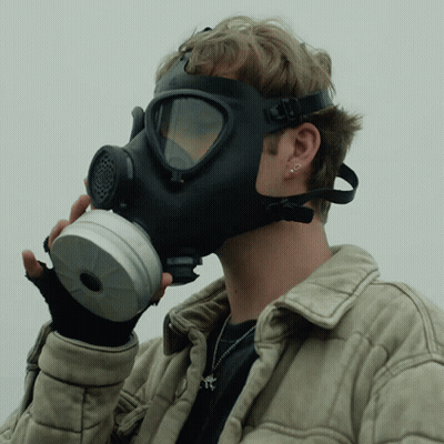 A Man Wearing A Gas Mask And Gloves GIF