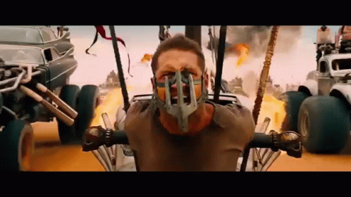 A Man Wearing A Gas Mask Is Sitting In A Buggy In A Movie . GIF