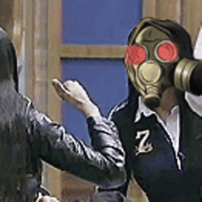 A Man Wearing A Gas Mask Is Standing Next To A Woman . GIF
