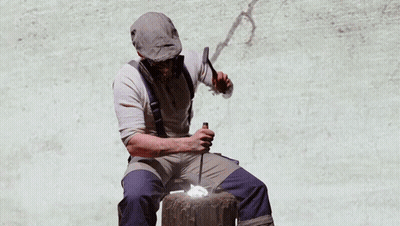 A Man Wearing A Gas Mask Sits In Front Of A Painting Of Hands Holding Money GIF