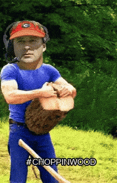 A Man Wearing A Georgia Bulldogs Hat Is Holding A Log And A Shovel With The Words Choppinwood Below Him GIF