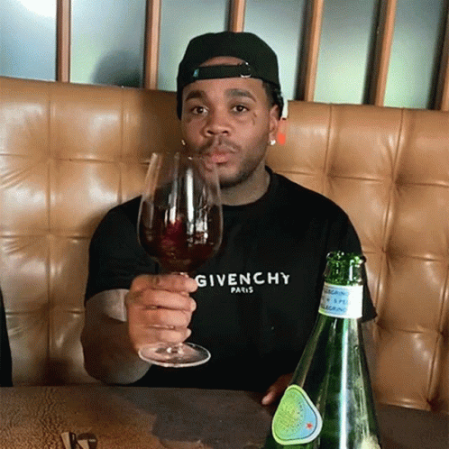 A Man Wearing A Givenchy Shirt Holds A Wine Glass GIF