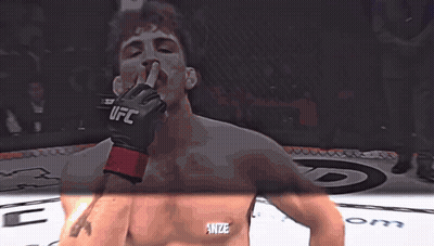 A Man Wearing A Glove That Says Ufc Holds His Finger To His Mouth GIF