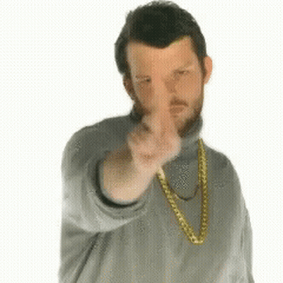 A Man Wearing A Gold Chain Around His Neck Is Pointing At The Camera GIF