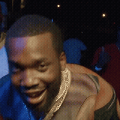 A Man Wearing A Gold Chain Around His Neck Is Smiling . GIF