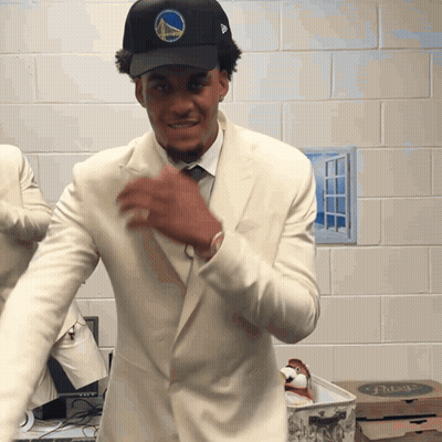 A Man Wearing A Golden State Warriors Hat And White Suit GIF