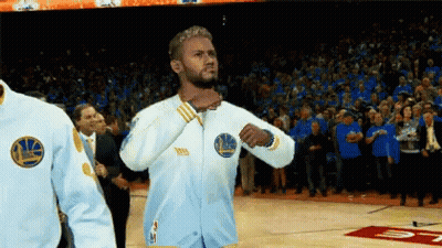 A Man Wearing A Golden State Warriors Jacket Stands On The Court GIF