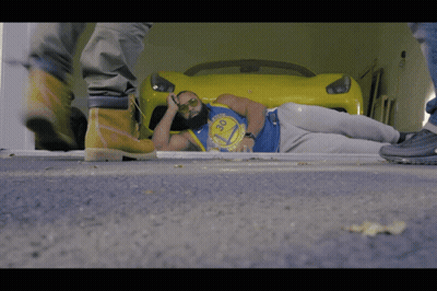 a man wearing a golden state warriors shirt lays on the ground