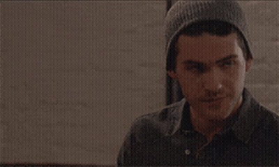 A Man Wearing A Gray Beanie Looks To His Left GIF