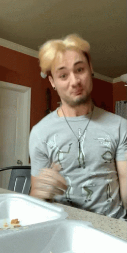 A Man Wearing A Gray Shirt With A Picture Of A Man On It Making A Funny Face GIF