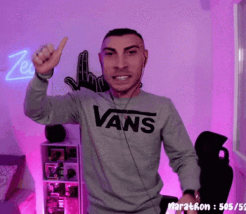 A Man Wearing A Gray Vans Sweatshirt Is Giving A Thumbs Up GIF