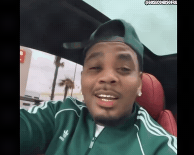 A Man Wearing A Green Adidas Jacket And A Hat GIF