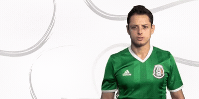 A Man Wearing A Green Adidas Jersey Is Standing In Front Of A White Background GIF
