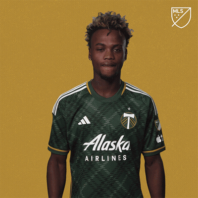 A Man Wearing A Green Alaska Airlines Shirt Holds Up A Yellow Card GIF