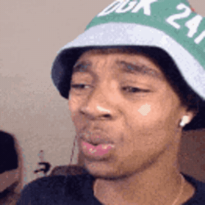 A Man Wearing A Green And White Hat With The Number 24 On It . GIF