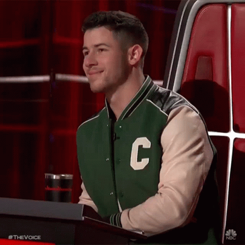 A Man Wearing A Green And White Varsity Jacket With The Letter C On It . GIF