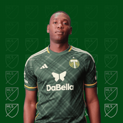 A Man Wearing A Green Dabella Jersey Stands In Front Of A Green Background GIF