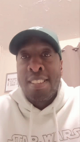 A Man Wearing A Green Hat And A White Star Wars Hoodie GIF
