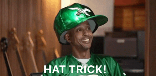 A Man Wearing A Green Hat That Says Hat Trick On It GIF
