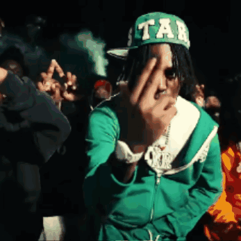 A Man Wearing A Green Jacket And A Green Hat With Tab On It GIF