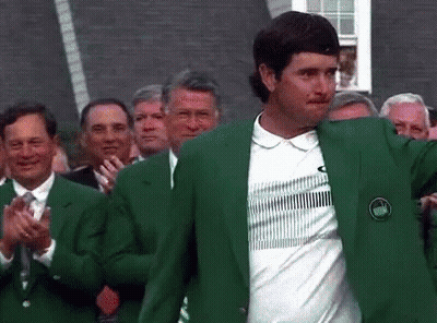 A Man Wearing A Green Jacket And A White Shirt Is Standing In Front Of A Crowd Of People Applauding . GIF