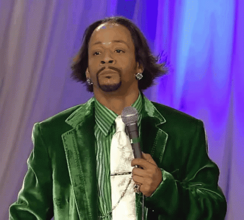 A Man Wearing A Green Jacket And Tie Is Holding A Microphone GIF
