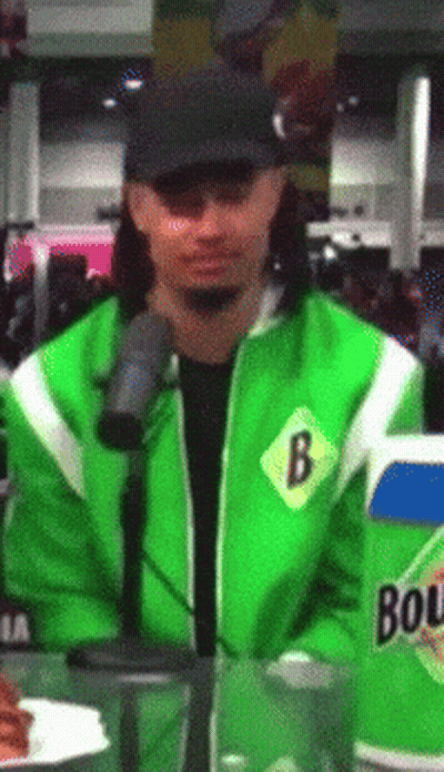 A Man Wearing A Green Jacket With The Letter B On The Front GIF