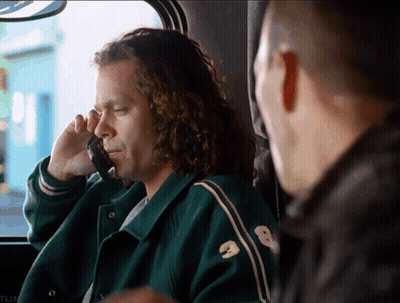 A Man Wearing A Green Jacket With The Number 8 On It Talks On A Cell Phone GIF