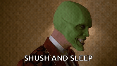 A Man Wearing A Green Mask Is Holding His Finger To His Mouth And Says Shush And Sleep . GIF