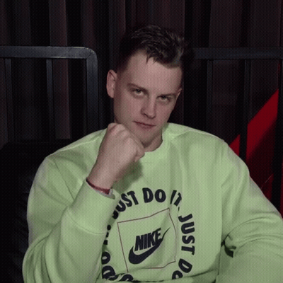 A Man Wearing A Green Nike Sweatshirt Has His Fist Up GIF