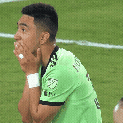 A Man Wearing A Green Nls Jersey Covering His Mouth With His Hands GIF
