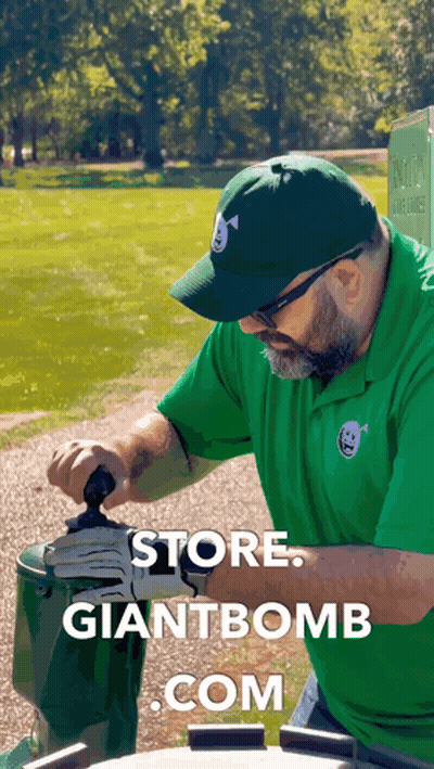 A Man Wearing A Green Shirt And A Green Hat Is Working On A Giant Bomb GIF